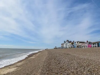 a sandy beach with houses and the ocean at The Retreat, Unique property located in calming woodland surroundings, Close to Aldeburgh and Thorpeness in Leiston