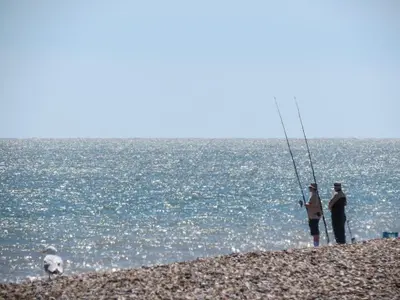 two people standing on a beach holding a fish at The Old Custom House in Aldeburgh