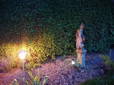 a statue and lights in a garden at night at Shear Annexe Flat in Cambridge