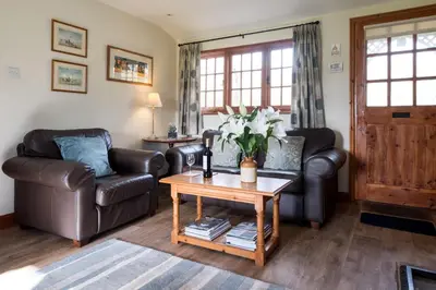 a living room with two leather chairs and a coffee table at 7 The Uplands in Thorpeness