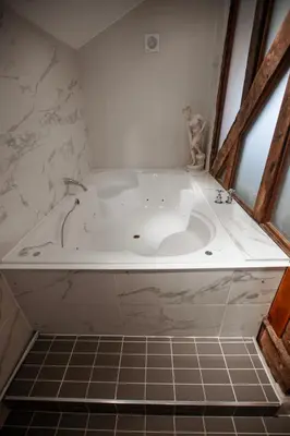 a white tub in a bathroom with a tiled floor at Best Western Brome Grange Hotel in Brome