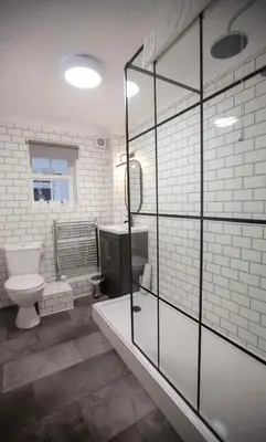 a bathroom with a toilet and a glass shower at Best Western Brome Grange Hotel in Brome