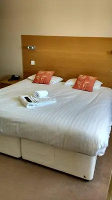 a bedroom with a large white bed with red pillows at The Anchor Ely in Ely