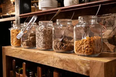 a shelf with jars filled with different types of nuts at The Cock Inn Hotel in Sheering