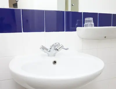 a bathroom with two white sinks and a mirror at Bull Hotel by Greene King Inns in Halstead