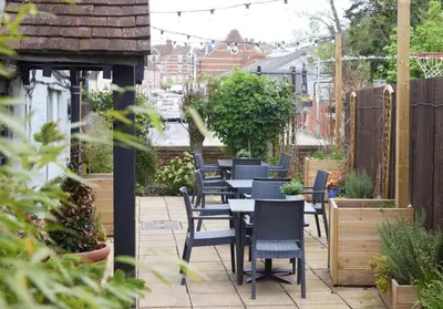a row of chairs and tables on a patio at Bull Hotel by Greene King Inns in Halstead