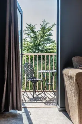 a balcony with a chair and a table on a porch at The Westleton Crown in Westleton