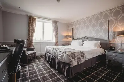 a hotel room with a bed and a chair at Greenwoods Hotel & Spa in Stock