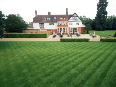 a large grass field in front of a building at Greenwoods Hotel & Spa in Stock