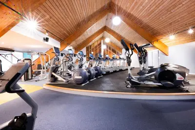 a gym with rows of exercise bikes and treadmills at Park Farm Hotel in Norwich