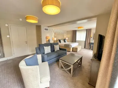 a hotel room with a bed and a blue couch at Park Farm Hotel in Norwich