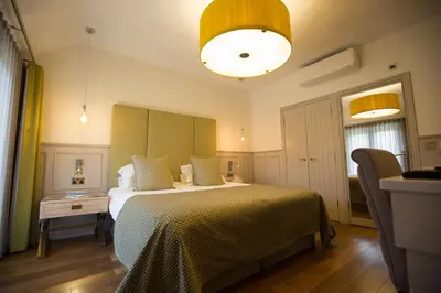 a bedroom with a large bed with a yellow blanket at Channels Hotel in Chelmsford