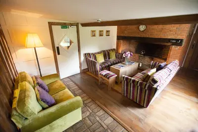 a living room with two couches and a fireplace at Channels Hotel in Chelmsford