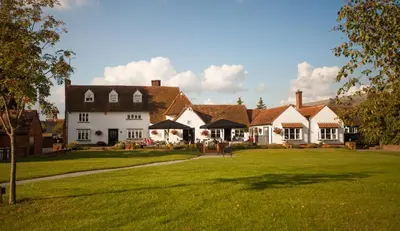 a large white house with a green lawn at Channels Hotel in Chelmsford