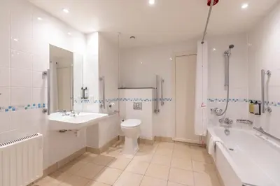 a bathroom with a tub and a toilet and a sink at Holiday Inn Basildon by IHG in Basildon