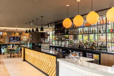 a bar with a lot of bottles of alcohol at Holiday Inn Basildon by IHG in Basildon