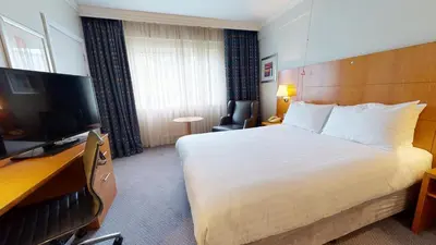a hotel room with a bed and a television at Holiday Inn Basildon by IHG in Basildon