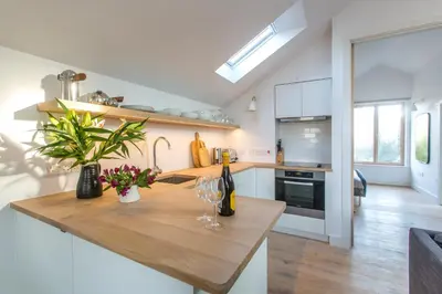 a kitchen with a wooden counter with wine glasses on it at Laurel Studio in Aldeburgh