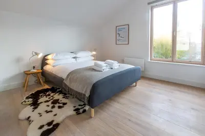 a bedroom with a bed and a rug on the floor at Laurel Studio in Aldeburgh