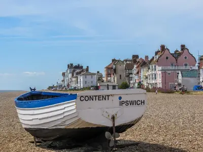 a boat sitting on the shore of a beach at Laurel Studio in Aldeburgh
