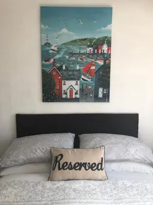 a painting hanging above a bed in a bedroom at Southend Airport Bed & Breakfast in Rochford