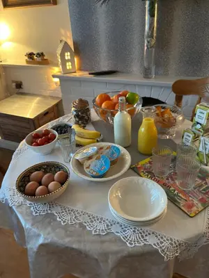 a table with plates and bowls of fruit and eggs at Southend Airport Bed & Breakfast in Rochford