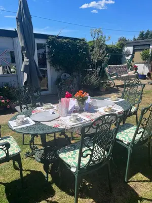 an outdoor table with chairs and an umbrella at Southend Airport Bed & Breakfast in Rochford
