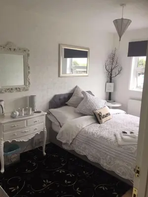 a bedroom with a bed and a table and a mirror at Southend Airport Bed & Breakfast in Rochford