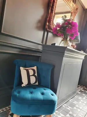 a blue chair with a pillow on it next to a mirror at Belle Vue Guest House in Denver