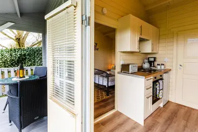 a kitchen with a door leading to a patio at The Retreat Log Cabin in Sudbury
