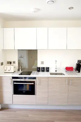 a kitchen with white cabinets and a dishwasher at Signet Apartments - Ceres in Cambridge