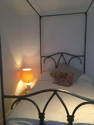 a bed with a lamp on a side table at Private luxury retreat in Sible Hedingham