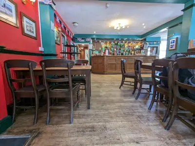 a restaurant with a table and chairs and a bar at The Earl Of Derby in Cambridge