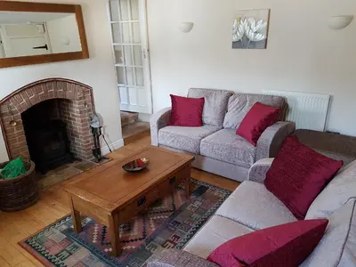 a living room with two couches and a fireplace at Flint Cottage in Brandon