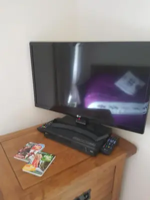 a flat screen tv sitting on top of a wooden table at Flint Cottage in Brandon