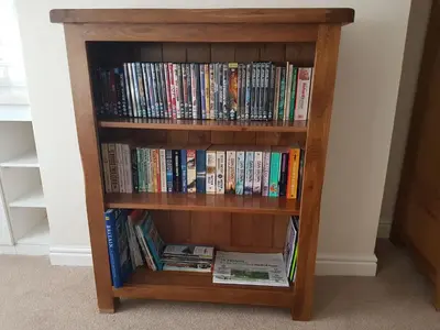 a book shelf filled with books and dvds at Flint Cottage in Brandon