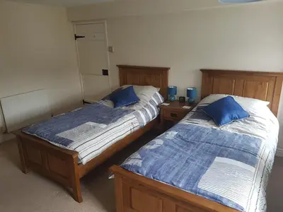 two beds sitting next to each other in a room at Flint Cottage in Brandon