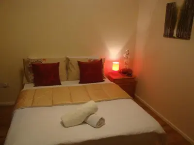 a bedroom with a bed with two rolled towels on it at Remarc Guest House in Takeley