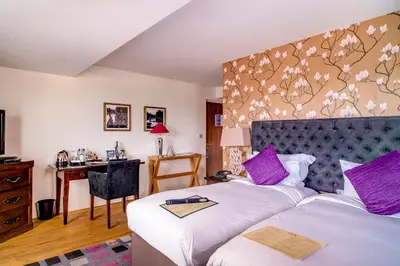 a hotel room with two beds and a desk at The Varsity Hotel & Spa in Cambridge