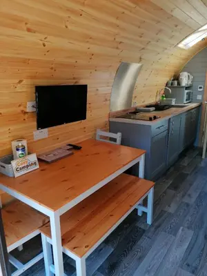 a kitchen with a wooden table in a cabin at Cosy Camping Suffolk in Ipswich