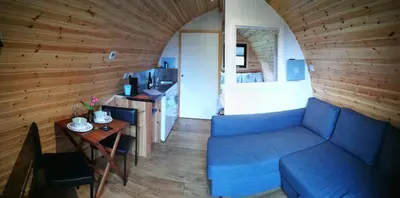 a living room with a blue couch and a table at Cosy Camping Suffolk in Ipswich