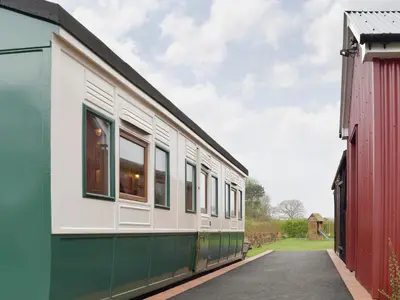 a train is parked next to a building at Wilby Halt-Ukc712 in Wetheringsett