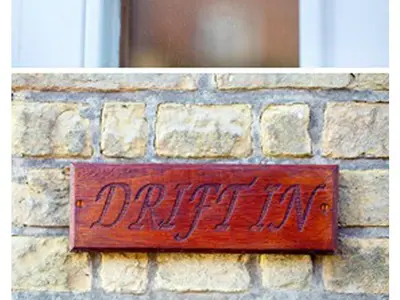 a sign on the side of a brick wall at Drift In in Aldeburgh