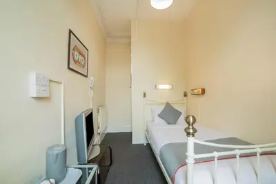 a hotel room with a bed and a tv at Devine Beach Hotel, Westcliff Southend-On-Sea in Southend-on-Sea