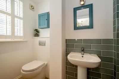 a bathroom with a sink and a toilet and a mirror at 2 Bell Lodge, Thorpeness in Thorpeness