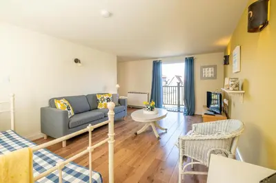 a living room with a couch and a table at 2 Bell Lodge, Thorpeness in Thorpeness