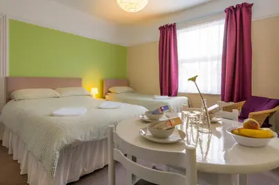 a bedroom with two beds and a table with fruit on it at Brunton House Guest House in Clacton-on-Sea