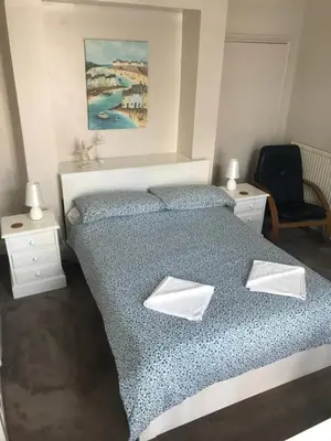 a bedroom with a bed with two pillows on it at Brunton House Guest House in Clacton-on-Sea