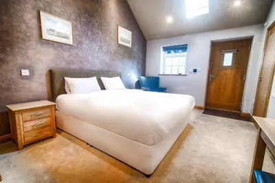 a bedroom with a large white bed and a wooden door at The Red Lion in Cambridge