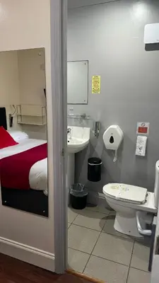 a bathroom with a bed and a sink and a toilet at The Railway Sleeper Lodge in Colchester